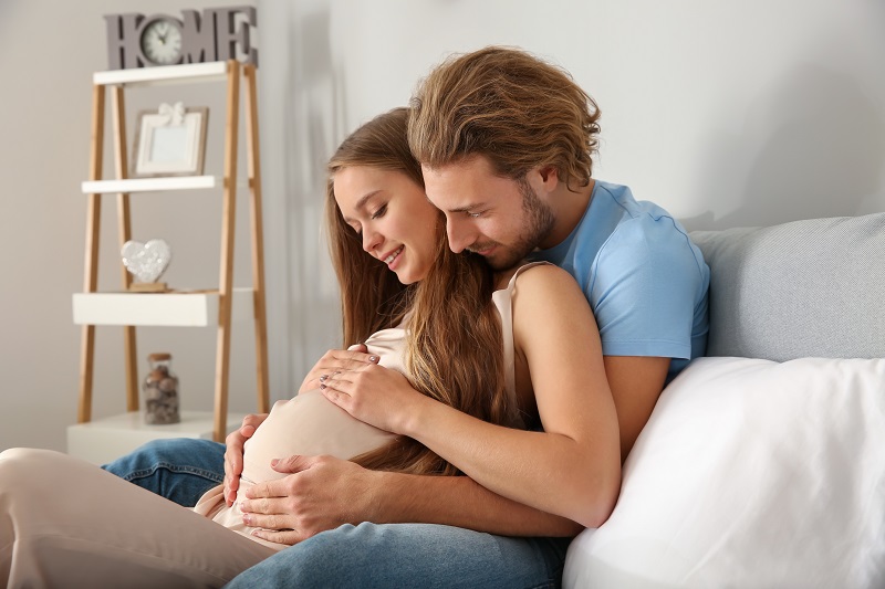 Young couple pregnant on couch